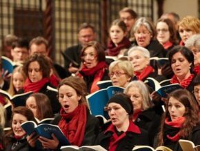 Kammerchor singt in schwarzer Kleidung mit roten Halstüchern